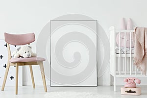 Plush toy on pink chair next to poster with mockup in baby`s roo