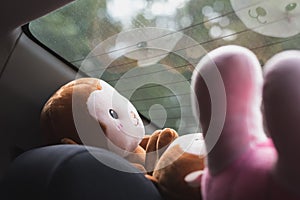 Plush toys in front of the rear window of a car