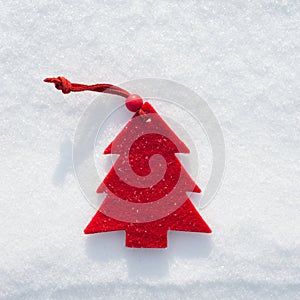 Plushy red fir tree toy on snow