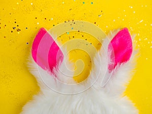 Plushy toy bunny rabbit ears. Happy easter concept. Yellow background. Easter minimal concept Picture with space for your text