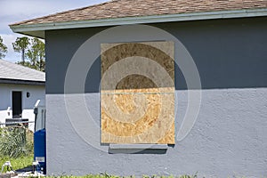 Plywood mounted as storm shutters for hurricane protection of house windows. Protective measures before natural disaster
