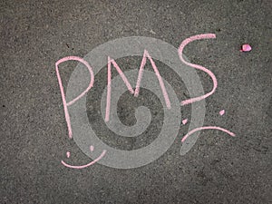 PMS Premenstrual syndrome with hand drawn happy&sad emojis. Using color chalk pieces