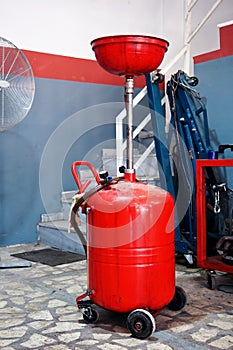 Pneumatic engine oil extractor or waste oil drainer machine in a car repair shop