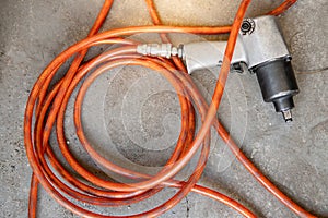 Pneumatic wrench with hose pipe on the floor photo