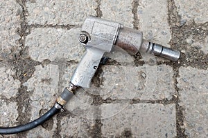 Pneumatic wrench lying on the floor of stone tiles