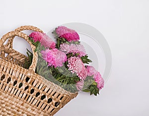 Pnk autumn flowers in a straw basket