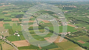 The Po Valley in Italy from the plane window during the landing of the airplane. Agricultural fields with green and brown colors