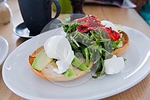 Poach eggs with arugula and dried tomato salad photo