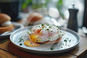 A poached egg bagel with greens on a white plate and on a blurred kitchen background. A healthy and delicious breakfast