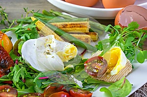 Poached egg with corn vegetables, grilled pepper, spinach, arugula, green beans and baby salad. Close up. Natural food