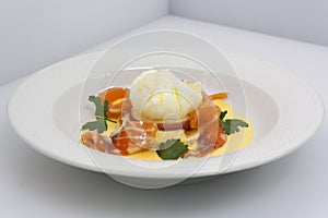 Poached egg on fresh tomato and thinly sliced salmon