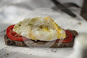 Poached egg on sourdough toast, with grilled tomatoes, mushrooms and salad leaves. A healthy, delicious breakfast or brunch