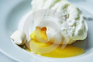 The poached egg is on a white plate