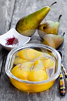 Poached pears with spices in syrup on the glass bowl