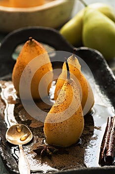 Poached pears with spices in syrup, rustic style. Delicious dessert for holiday. Selective focus,backlight