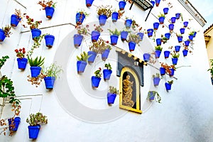 Poble Espanyol tourist attraction old narrow street with white walls decorated with blue flower pots in traditional andalusian