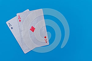 Pocket aces pair hand on bright blue flat lay background for poker, betting and casino concepts