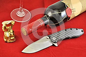 Pocket folding knife stainless blade carbon handle wine glass red background