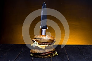 A pocket knife in a burger. Folding knife and burger photo