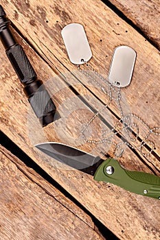 Pocket knife, dog tags and torch, top view.
