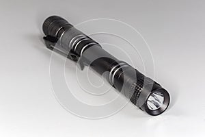 Pocket tactical electric LED mini flashlight on a gray background