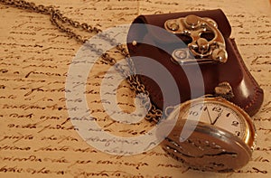 Pocket watch on an ancient manuscript