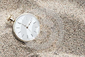 Pocket watch buried in sand