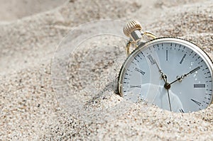 Pocket watch buried in sand photo