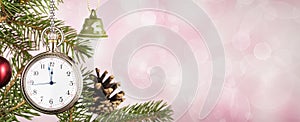 Pocket watch on Christmas tree branch on pink background