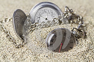 Pocket watch covered with sand.