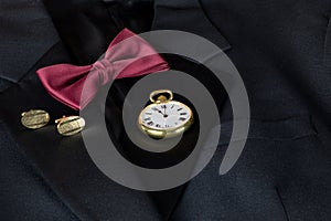 Pocket Watch with Cuff Links and Bow Tie on a Black Dinner Jacket