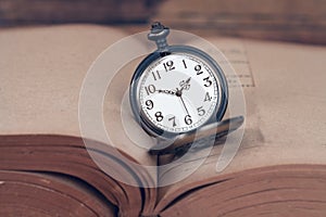 Pocket watch on old books.