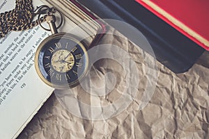 Pocket Watch with Old Books on Crumpled Paper in Vintage Tone