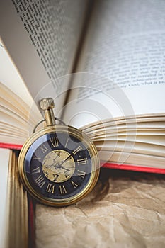 Pocket Watch with Old Books on Crumpled Paper in Vintage Tone