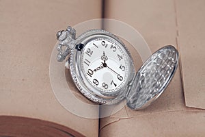 Pocket watch on old books.