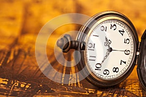 Pocket watch on old map background,