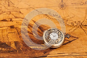 Pocket watch on old map background,