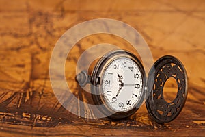 Pocket watch on old map background,