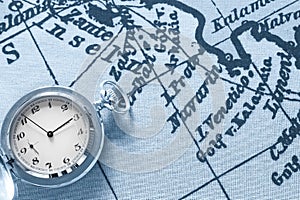 Pocket watch on old map background, vintage style light and tone.Travel, geography, navigation, tourism and exploration concept