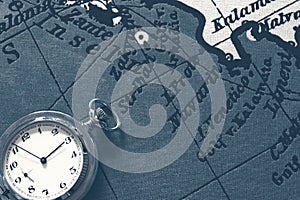 Pocket watch on old map background, vintage style light and tone.Travel, geography, navigation, tourism and exploration concept