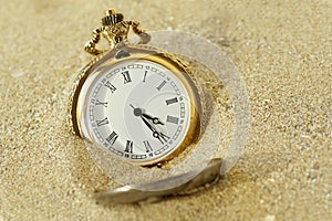 Pocket watch in the sand - Concept of time passing