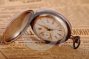 Pocket watch on vintage newspaper