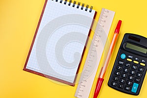 Pocketbook and calculator on yellow background. photo