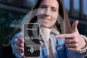 Podcast application. Audio podcast on mobile smartphone screen application in woman hand. Happy young sexy girl holding
