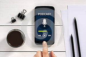 Podcast concept on smart phone screen with office objects