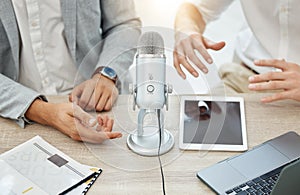 Podcast, interview and business people hands, microphone and broadcast, talking or news, finance and advice in office