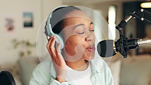 Podcast, radio and report with a woman recording or live streaming content with a microphone and headphones. Influencer