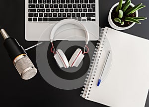 Podcast recording concept with audio recording equipment on dark table