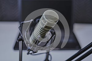 Podcast microphone with laptop computer in background