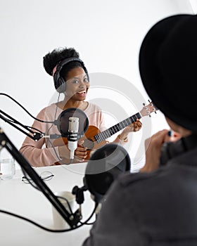 Podcasters, African American and European woman with headphones and microphone